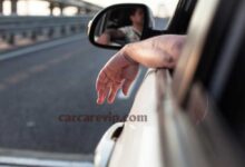 man driving with arm outside car window